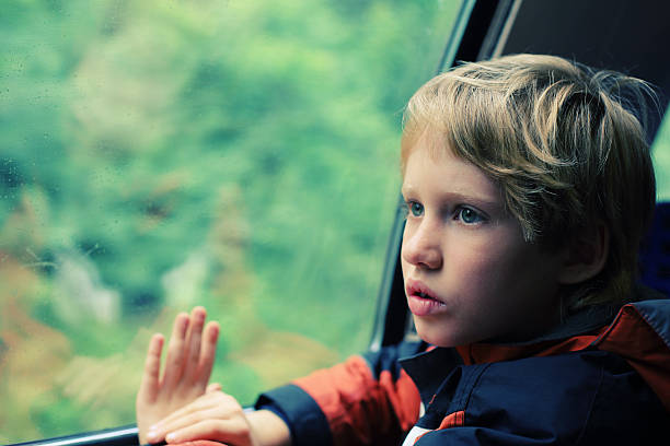 istock 7 years old boy sitting in the train 488244022