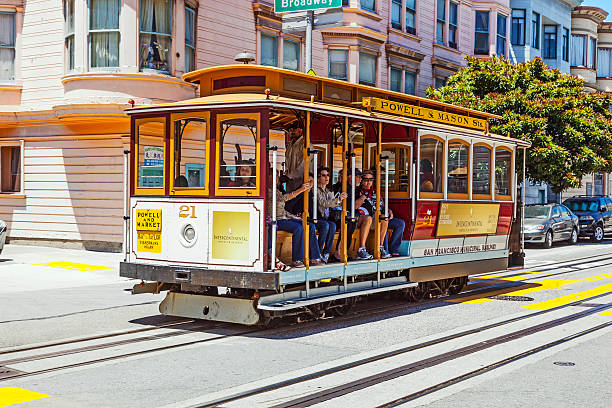 people travel with famous Cable Car Bus near Fisherman's Wharf San Francisco, USA - June 20, 2012: people travel with famous Cable Car Bus near Fisherman's Wharf 2 in San Francisco, California. Cable car trains first began operating in the city in 1873. fishermans wharf san francisco photos stock pictures, royalty-free photos & images