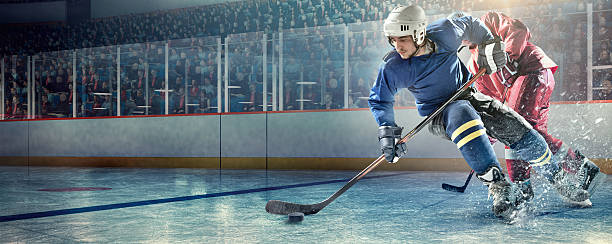 Ice hockey players in action Illustration of hockey player making a game in stadium. In the background are other players and thousands of spectators sit in the stands. hockey puck photos stock pictures, royalty-free photos & images