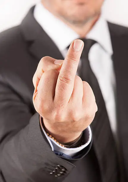A man with a black suit shows his middle finger