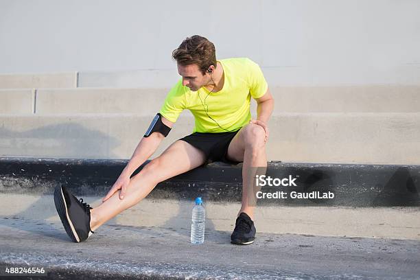 Men Runner Touching Pulled Leg Muscle While Resting After Training Stock Photo - Download Image Now