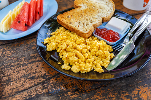 Breakfast with scrambled eggs, toast and jam