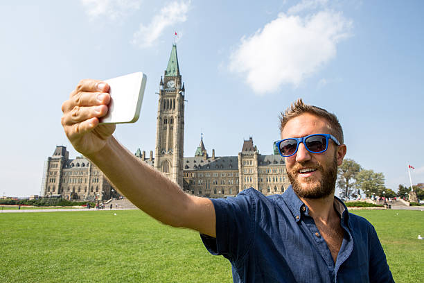 istock Young cheerful man in Ottawa-Canada taking a selfie portrait 488250756