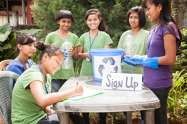 istock Teenagers register at recycling volunteer check-in table. Multi-ethnic group. 488251170