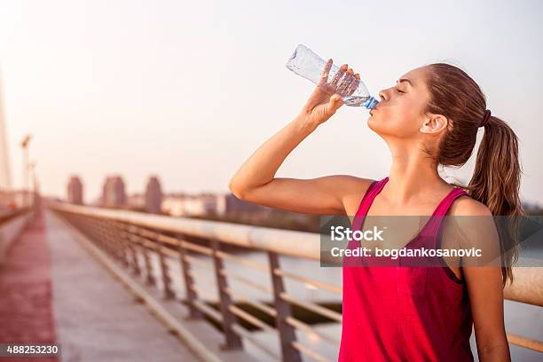Sportswoman Hydrating On The Bridge Stock Photo - Download Image Now - Drinking, Water, Women