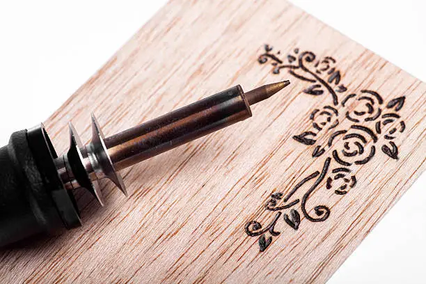 A pyrography tool and a floral model.