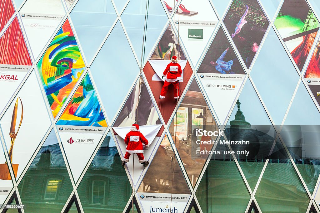 two climber dresses as Santa Claus climb down the facade Frankfurt, Germany - December 21, 2012: two climber dresses as Santa Claus climb down the Myzeil facade to open a new christmas window in Frankfurt, germany. Myzeil openend in 2008 and is the master peace of architect Massimiliano Fuksas. Santa Claus Stock Photo