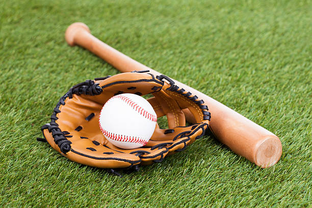 Leather Glove With Baseball And Bat Leather Glove With Baseball And Bat On Green Pitch baseball glove stock pictures, royalty-free photos & images