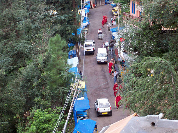 Buddhist monks in McLeod Ganj McLeod Ganj, India - January 2, 2008: Buddhist monks and local people walking along a busy road in McLeod Ganj. lama religious occupation stock pictures, royalty-free photos & images