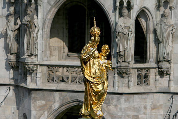 Munich, Germany - May 09, 2024: Historical Sculpture of Angel with Snake in Marienplatz Square, Munich – A striking figure from the Mariensäule (Mary's Column), this baroque sculpture represents the triumph of good over evil and dates back to 1638