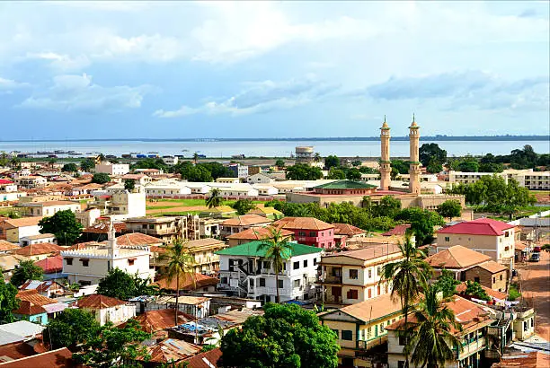 Banjul, The Gambia: skyline of the low-rise Gambian capital with the River Gambia as Background - minarets of King Fahad Mosque on the right