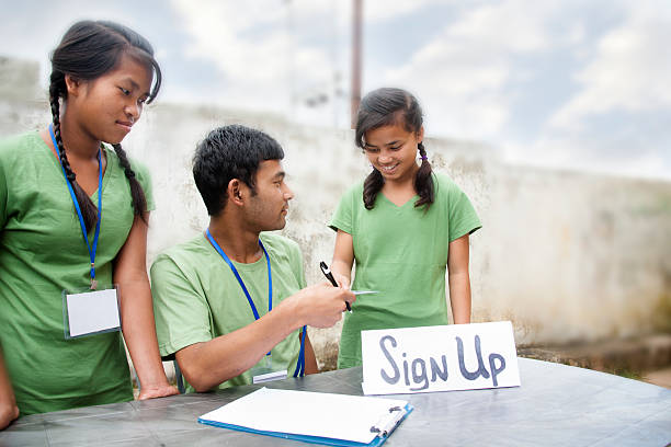 istock Teenagers register at volunteer check-in table. Multi-ethnic group. 488270114