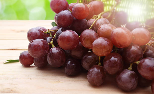 istock Bunch of red grapes on wooden table 488271574