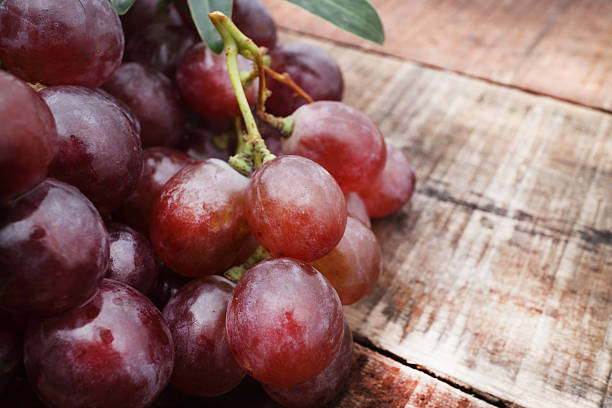 istock Bunch of red grapes on wooden table 488271782