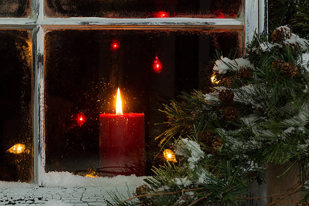 istock Glowing Christmas candle in frosted home window 488276148