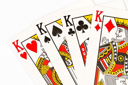 Four Kings playing cards in a macro closeup shot against a white background