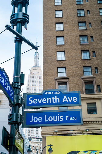 New York City, US - November 23, 2013: Seventh Avenue and Joe Louis Plaza street signs, with Empire State Building in the background