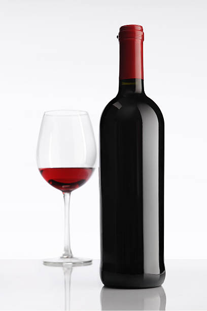istock Glass with red wine bottle on white background 488281087