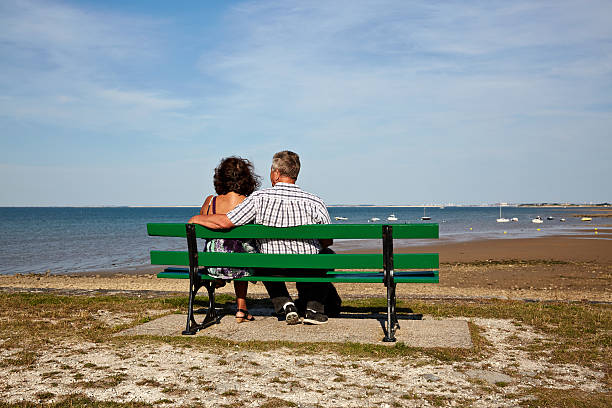 istock Senior couple on  beach bench at seashore 488283278