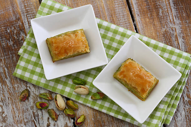 istock Pistachio baklava in white bowls on checkered cloth on wood 488304892