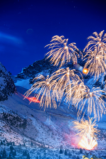Brightly colorful fireworks. Night skiing. Winter, view of  high snow mountain landscape.  Passo Tonale ski area. Passo del Tonale is a wide, panoramic, natural amphitheatre lying between 1,884 and 3,100 metres above sea level.  The grain and texture added.