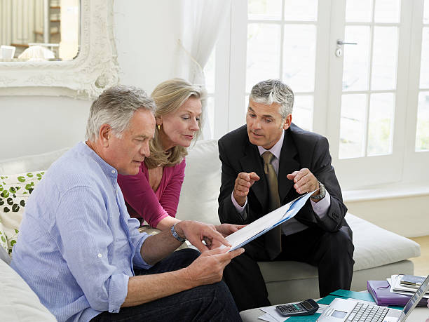 istock Couple With Financial Advisor At Sofa 488306405