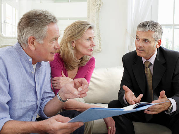 istock Couple With Financial Advisor At Sofa 488306409
