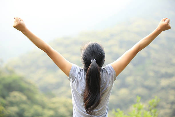 istock cheering hiking woman open arms at mountain peak 488307733