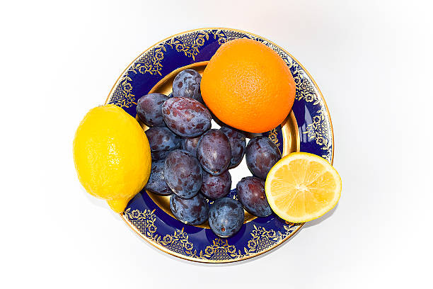 ciruelas y naranjas, limones en una placa. - plum yellow eating beauty and health fotografías e imágenes de stock