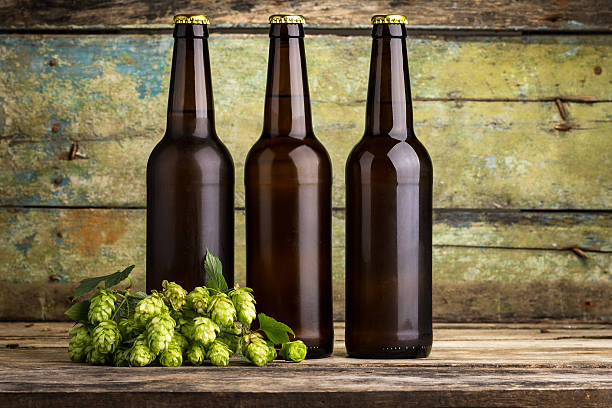 istock Three bottles of beer on wooden background 488311406