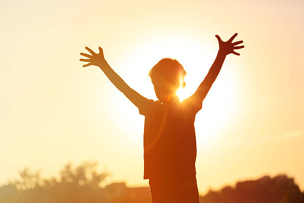 istock happy little boy at sunset sky 488311906