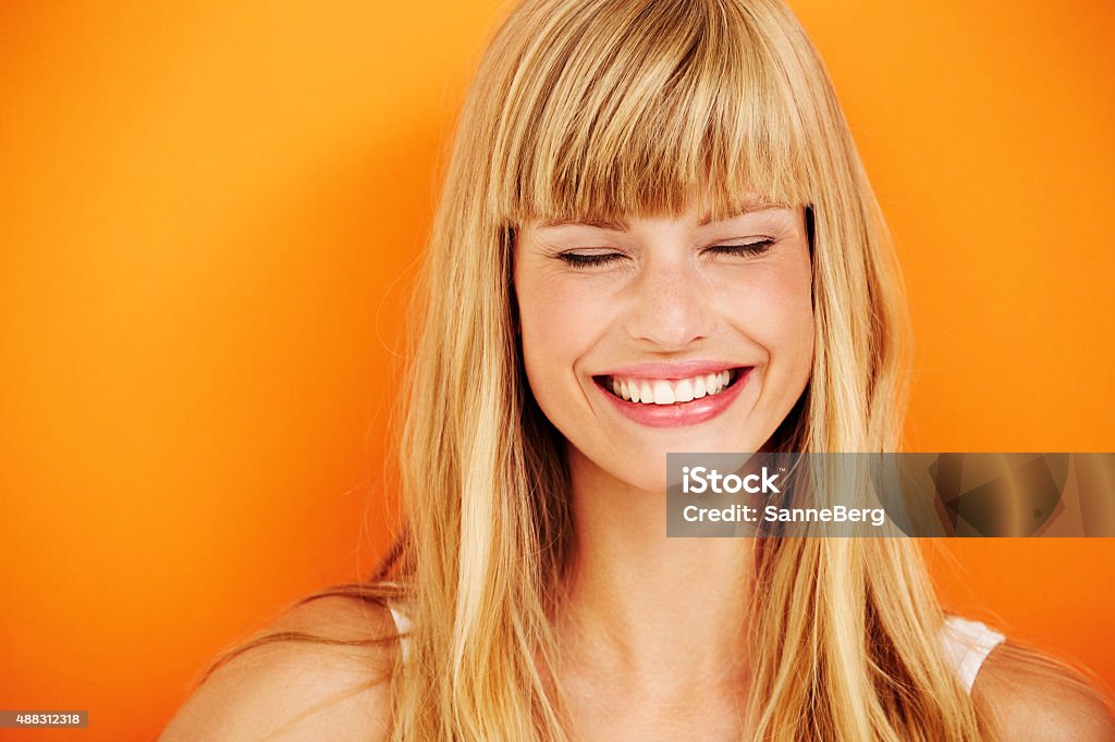 Young blond woman laughing Young blond woman laughing in studio Smiling Stock Photo