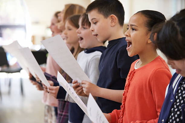 groupe d'enfants chantant en chœur ensemble - singing lesson photos et images de collection