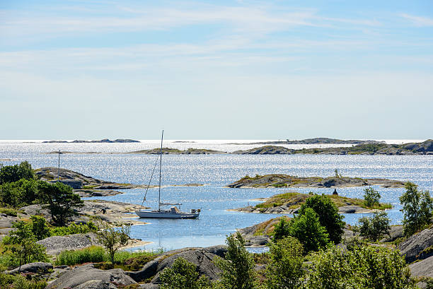 vertäut segelboot und skerries in der sonne - inselgruppe stock-fotos und bilder