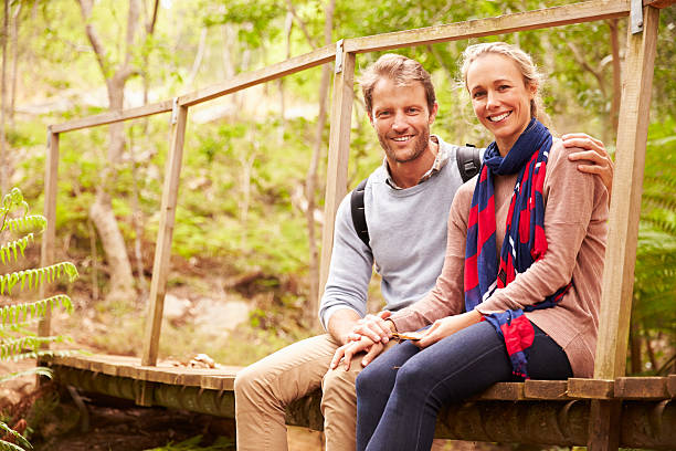 istock Happy couple sitting on a bridge in a forest 488316226
