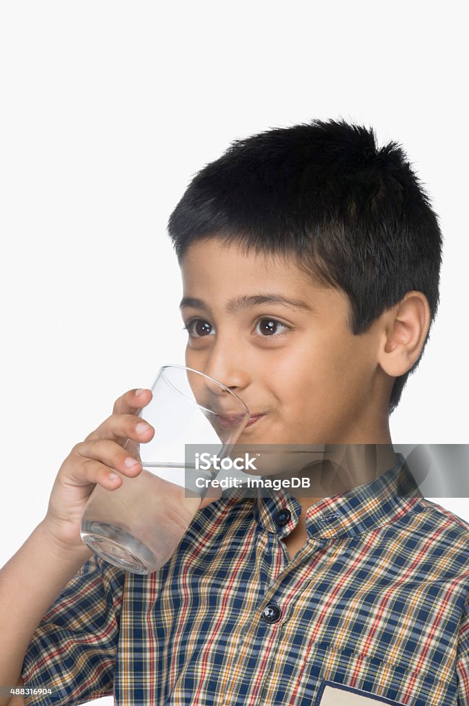 Schoolboy drinking a glass of water Boys Stock Photo