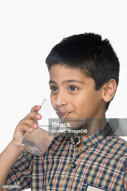 Schoolboy Drinking A Glass Of Water Stock Photo - Download Image Now - Boys, Drinking Water, Glass - Material