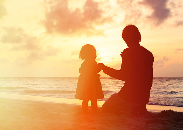 istock Father and little daughter holding hands at sunset 488318536