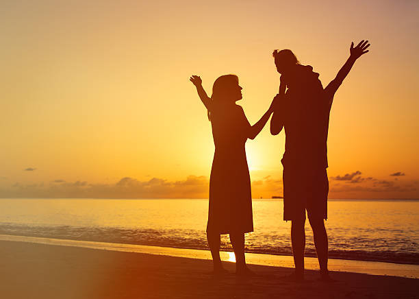 istock happy family with kid having fun on sunset beach 488318820