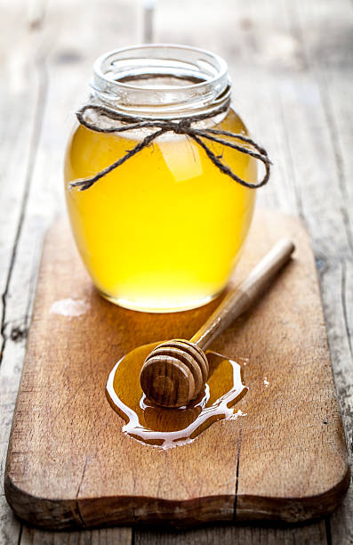 istock Bowl of honey on wooden table 488319158
