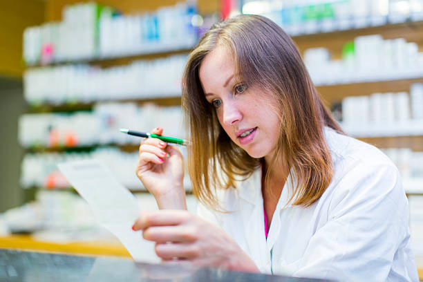 istock Cute female pharmacist checking prescription 488324255