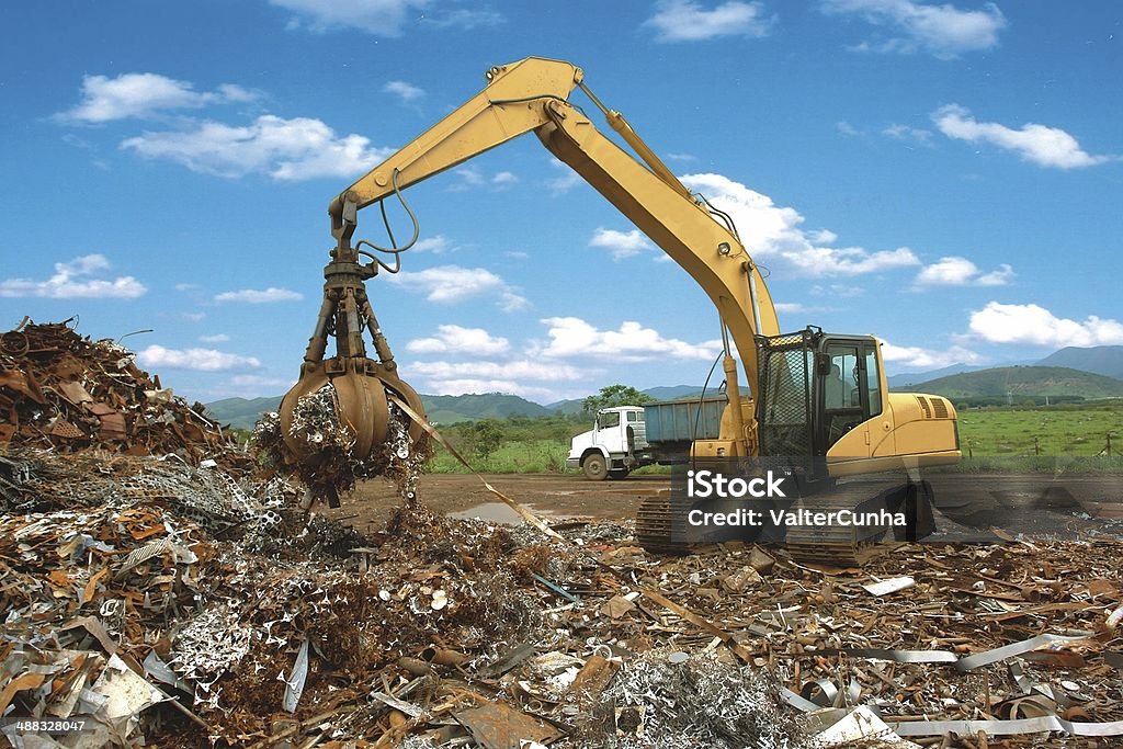 Excavators with clamshell collects junk dumped on the floor Hydraulic crawler equipped with mechanical claw collects scrap to supply steel steel industry in Brazil Junkyard Stock Photo