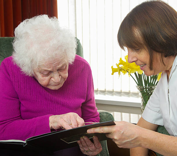 istock Care worker nurse visiting and caring for an elderly client 488330759