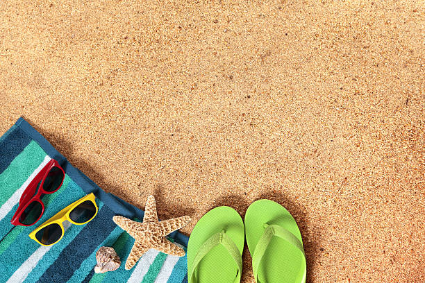 Close-up of a woman’s flip-flops on warm beach sand, with soft sunlight and a clear blue sky in the background. The image captures a peaceful summer moment, evoking feelings of freedom, rest, and sun-soaked relaxation. With space for product placement, it’s perfect for promoting skincare, travel destinations, beachwear, or lifestyle brands focused on self-care and summer vibes