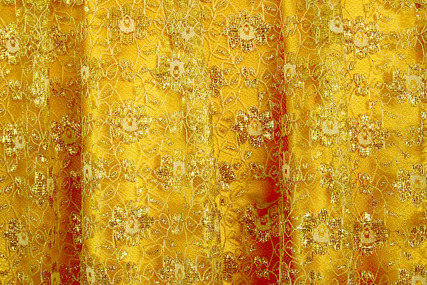 istock Gold peach lace sits on a gold silk background 488352804