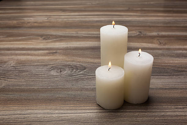 istock White candles on the board from oak 488354356