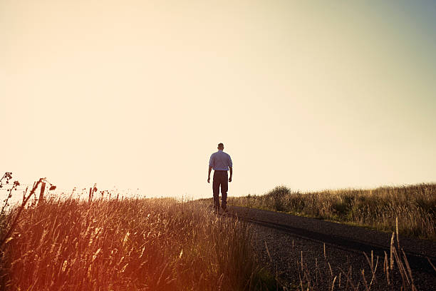 istock Solitude, Man stood alone on a country road 488355398