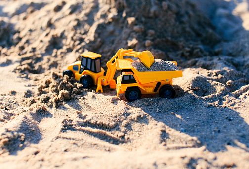 toy truck and excavator mining of sand in a quarry