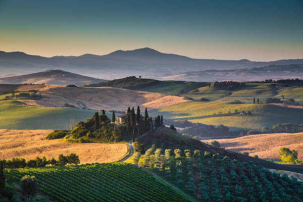 Scenic Tuscany landscape at sunrise, Val d'Orcia, Italy Scenic Tuscany landscape with rolling hills and valleys in golden morning light, Val d'Orcia, Italy. siena italy stock pictures, royalty-free photos & images