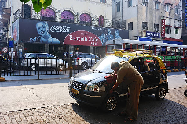 Mumbai, India - February 24, 2015: a Taxi driver was cleaning his car at roadside, downtown in Mumbai, India, to start business in the new day.